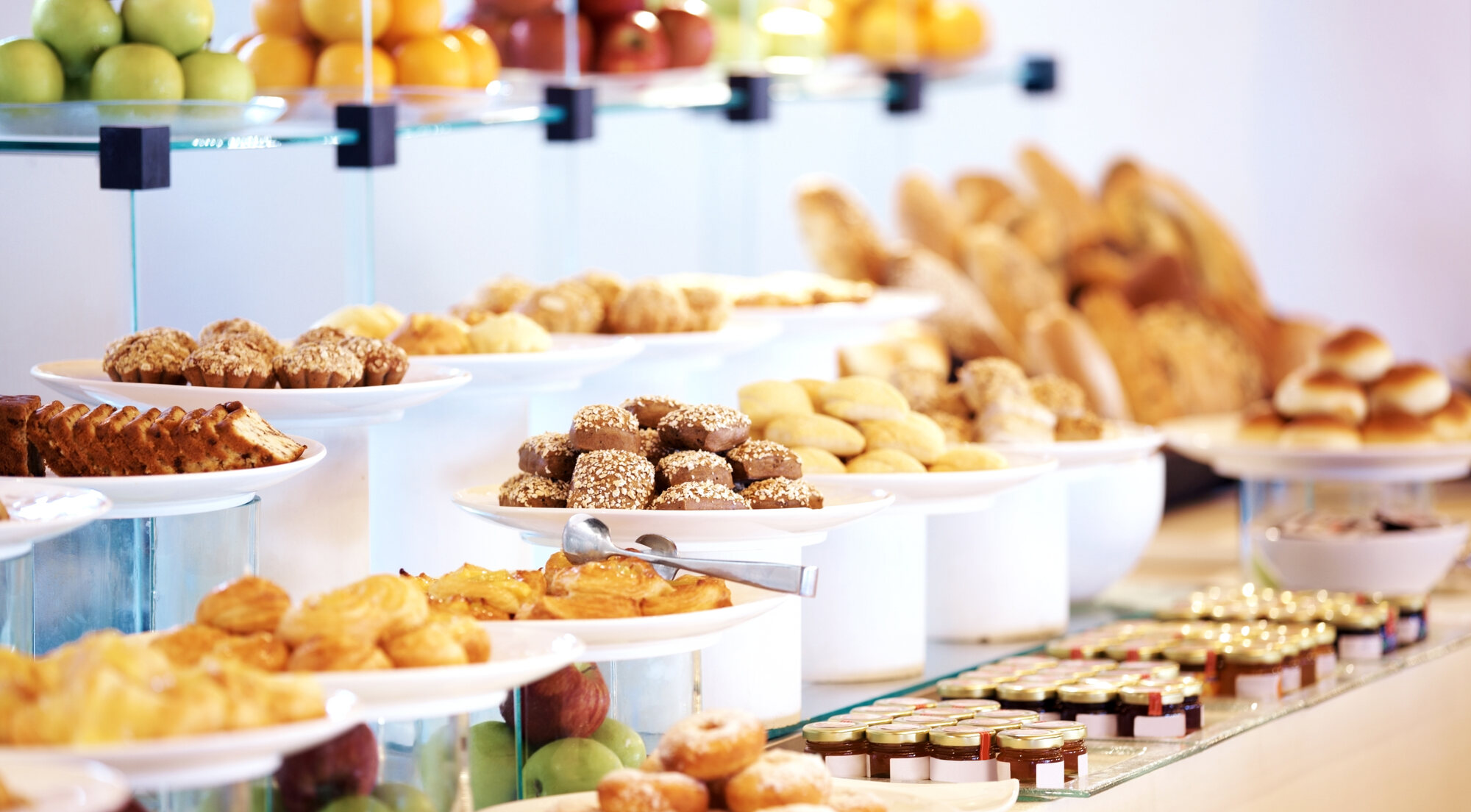 Continental breakfast spread with pastries, muffins and preserves