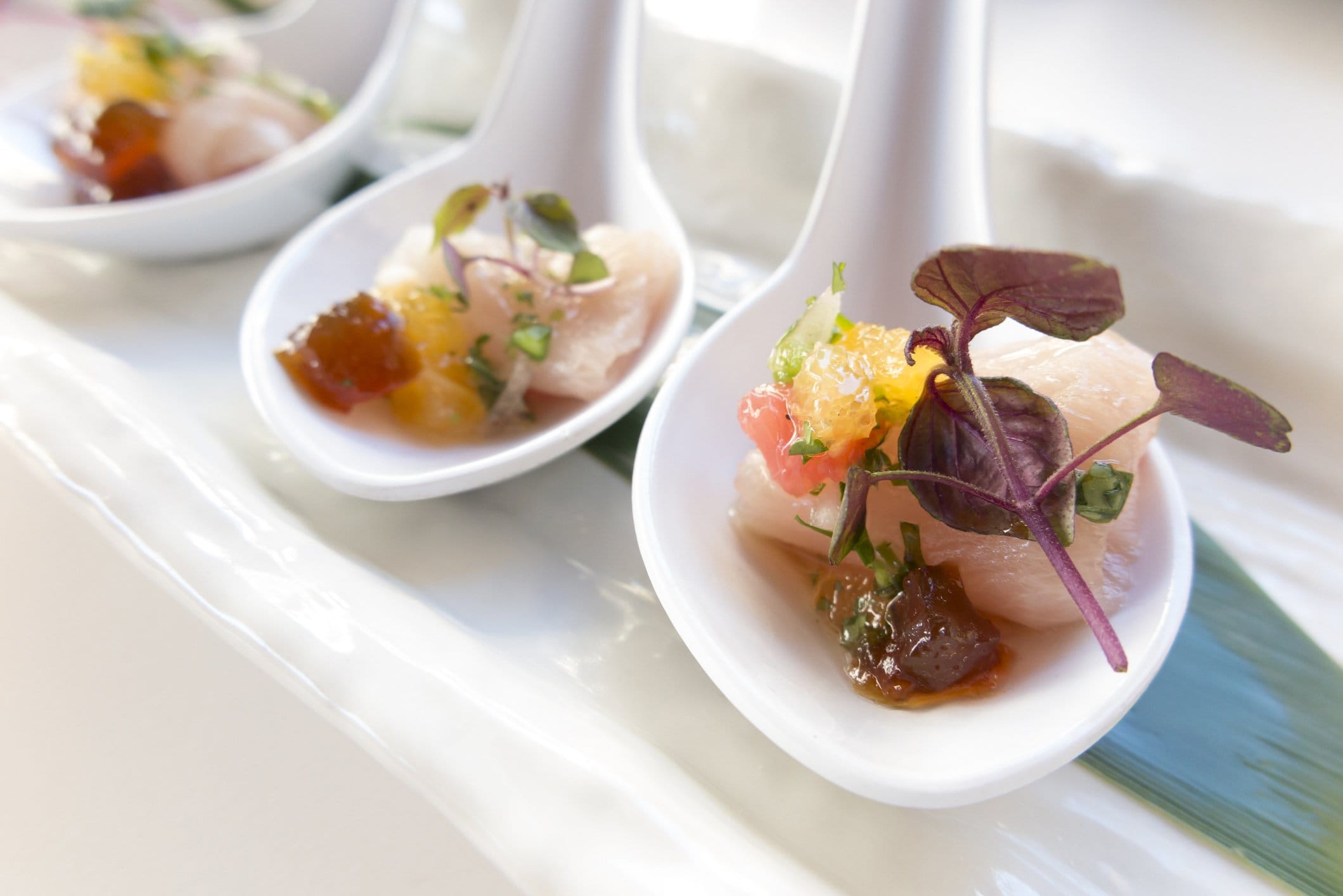 Crudo canapés on spoons with citrus and micro herbs