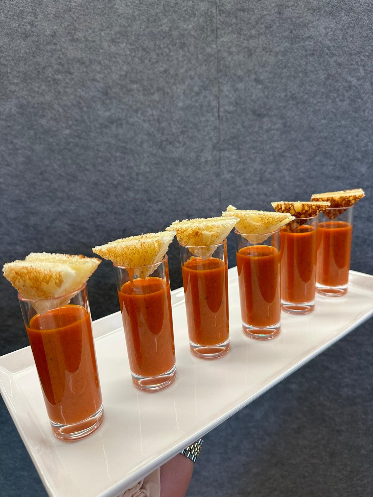 Tomato soup shooters topped with mini grilled cheese triangles