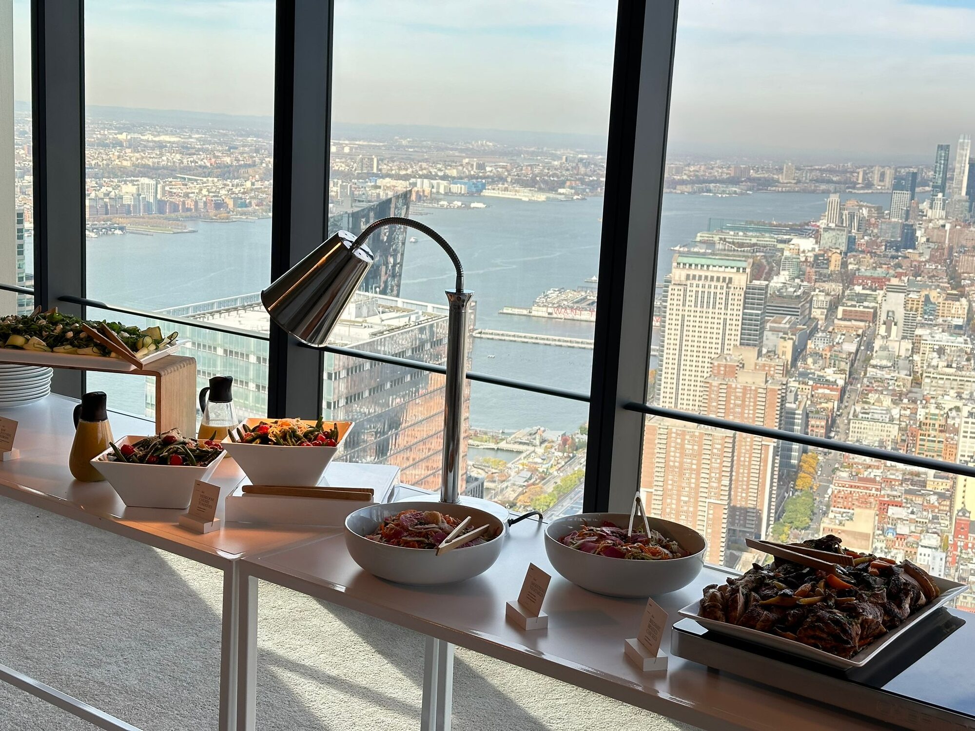 Buffet lunch service beside floor-to-ceiling Manhattan skyline views