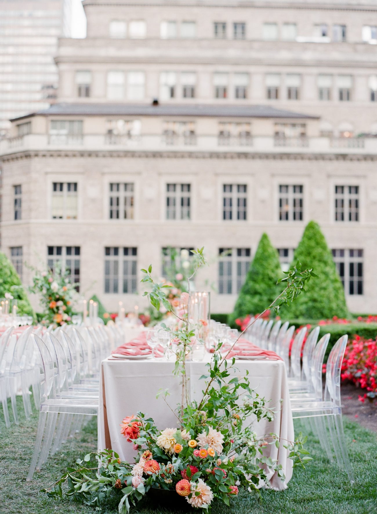 Rooftop wedding reception tables with coral florals in New York City